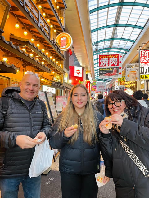 Osaka Street Food Adventure: Taste Local Flavors with Guide - Eating kushikatsu beneath Tsutenkaku